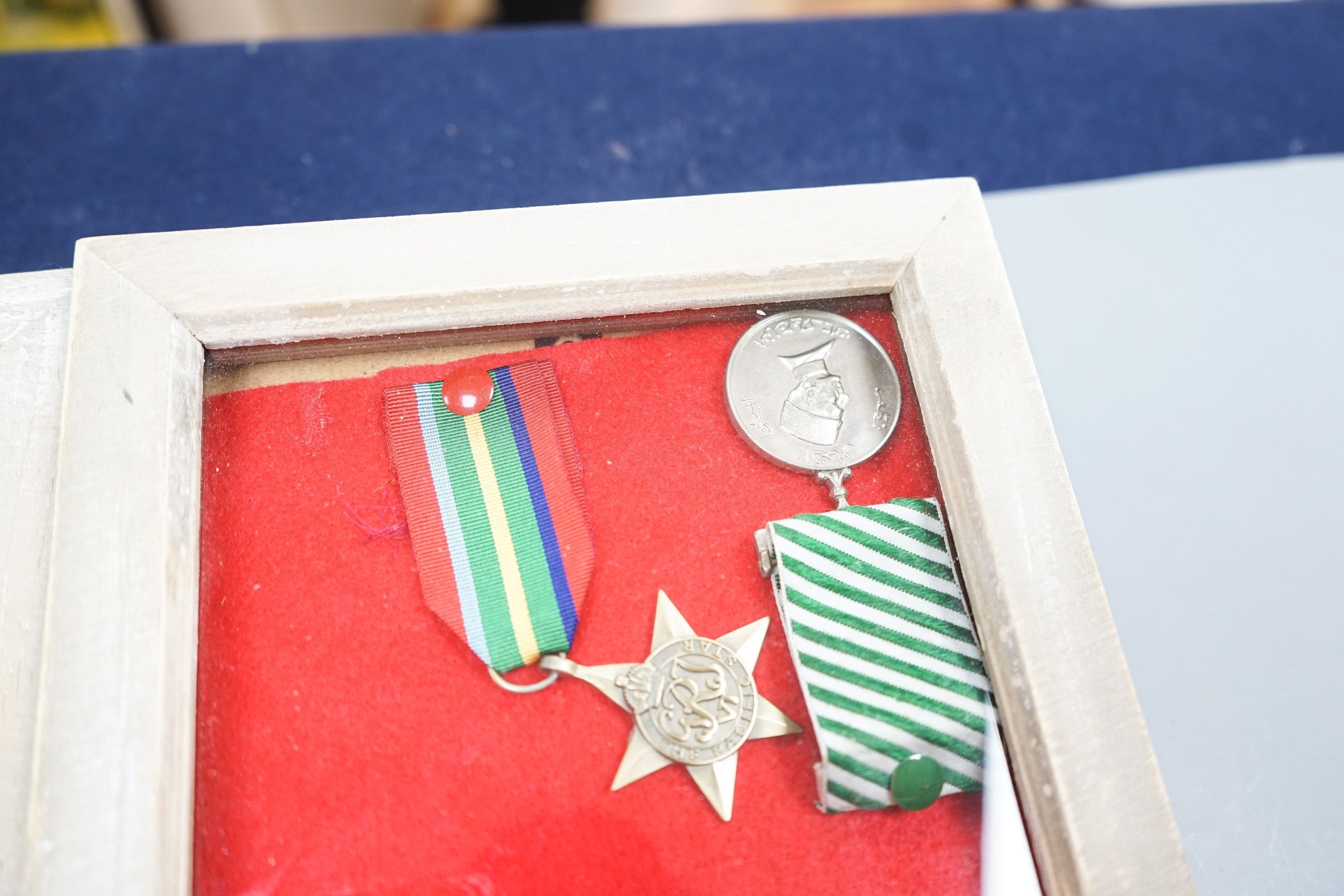 A Canadian First War Christie Brown and Co printed biscuit tin, framed medals, a trench art brass cigarette case and a reproduction German dagger.